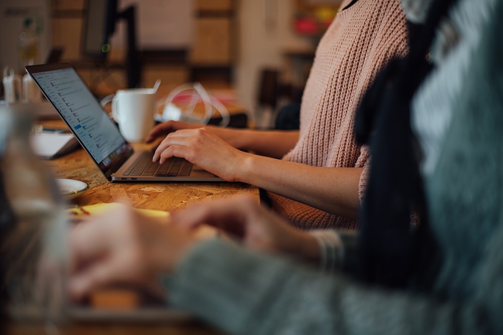 Nahaufnahme Hände auf einer Laptoptastatur