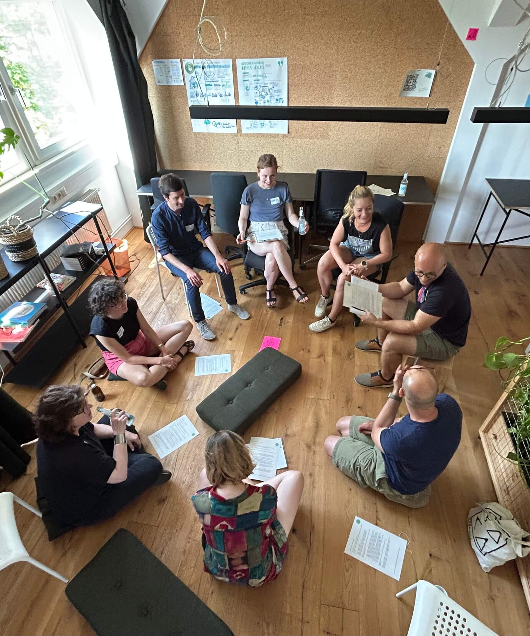 Beispiel-Foto eines Workshops auf der KOON23 mit Menschen, die im Kreis auf dem Boden sitzen
