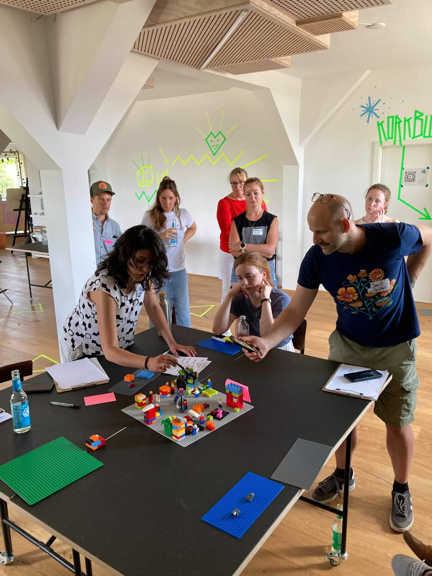 Beispiel-Foto eines Workshops auf der KOON23 mit Menschen, die um ein 3D-Modelling aus Lego stehen