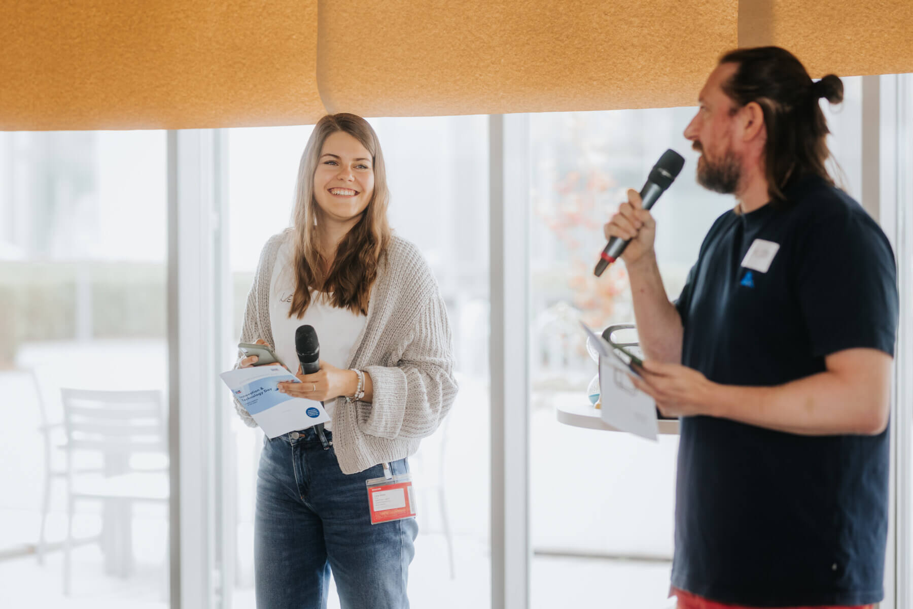 Das Facilitator*innen-Duo Lena und Jacob mit Mikrofon in der Hand